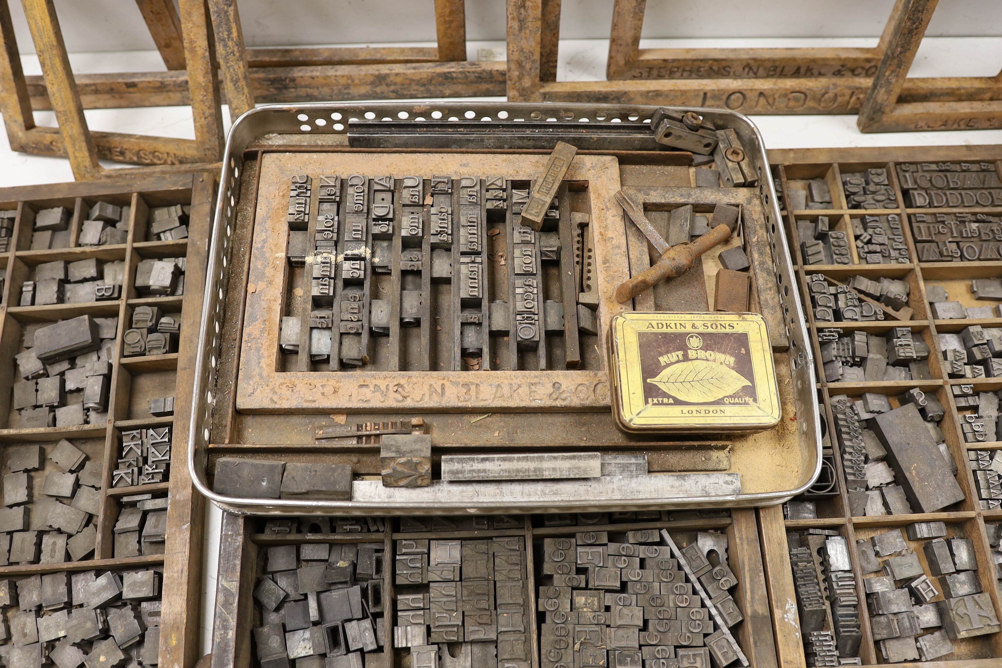 Three trays of metal printing type: chases, quoins and spacing bars